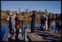 Men standing on the pont (ferry) at Bagani, including Manuel, as it returns across the river