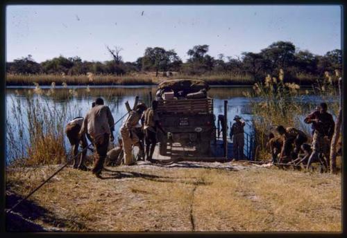 Men loading the expedition GMC on the pont (ferry) at Bagani