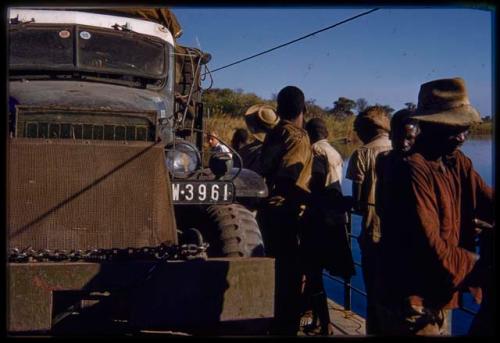 Men pulling cables next to the expedition GMC on the pont (ferry) at Bagani