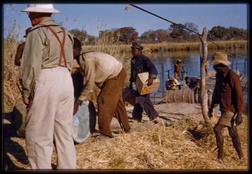 Men unloading barrels from the pont (ferry) at Bagani