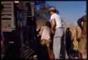 Men filling barrels, with Nicholas England watching