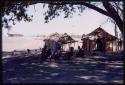 Woman standing and people sitting in the camp of Father Jean Marie Molier