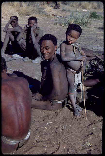 Children, "Fathers and sons": Bo sitting, with Be leaning against him, unidentified men sitting near them