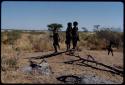 Children, Groups, play: Girls playing Tamah n!o’an (the ball game) on a termite mound, with a pan filled with water in the distance