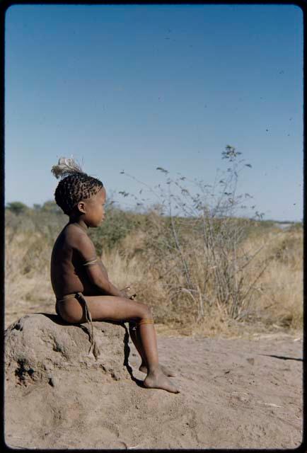 Children, Portraits: "Little ≠Gao" wearing an ostrich feather in his hair, sitting on an anthill