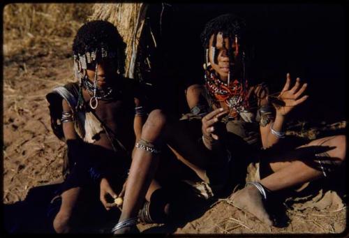 Children, Toys: ≠Nisa (daughter of "Gao Medicine" and /Naoka, wife of "/Gao Music") making a "cat's cradle," sitting in front of a skerm with ≠Gisa