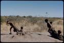 Children, Toys: Two groups of children pulling other children on karosses on an anthill