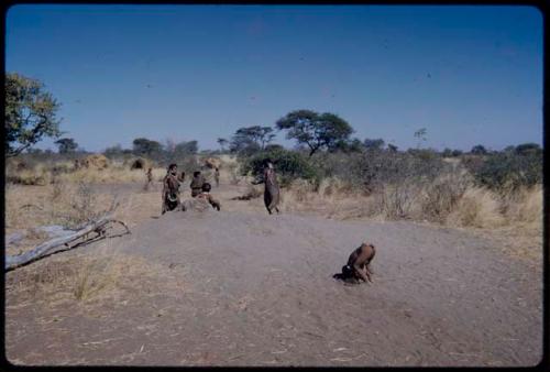 Children, Groups, play: Children playing on a termite mound, with skerms in the background