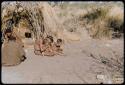 Children, Fathers and sons: /Gunda (son of "Old ≠Toma" and /Gam) sitting with two children in front of a skerm