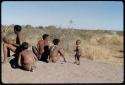 Children, Fathers and sons: Group of boys sitting on an anthill, with "≠Gao Lame" playing a //guashi and /Gaishay (son of "Gao Medicine" and Di!ai) dancing