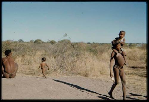 Children, Fathers and sons: Boy carrying /Gaishay across a termite mound