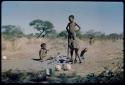 Children, Imitation: Boys standing and sitting beside the ashes of a fire, with /Gaishay (son of ≠Toma and !U) smoking a pipe