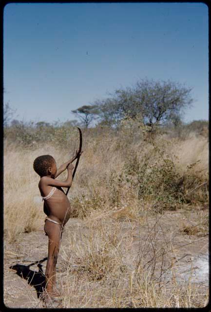 Children, Socialization--hunting, carrying: !Naishi aiming a bow and arrow