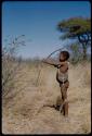 Children, Socialization--hunting, carrying: !Naishi aiming a bow and arrow, side view