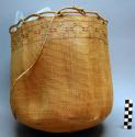 Basket with handle - open twined weave with woven worsted decoration.