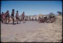 Dance: "Crooked /Qui" leading the men dancing counter-clockwise toward the circle of women sitting at a daytime dance