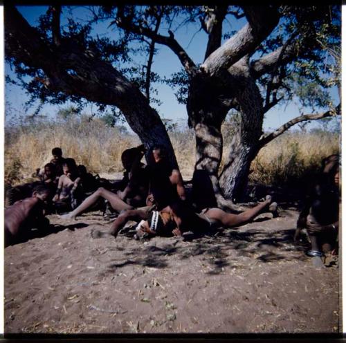 Dance: "/Qui Hunter" in trance, lying under a tree at a daytime dance, with "Old ≠Toma" beside him (half of stereo 2001.29.5195)