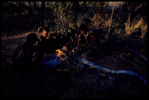 Fire, Evening: Four people sitting by a fire in the late afternoon