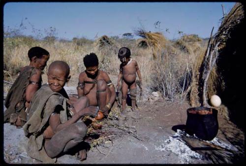 Food, Cooking: /Naoka preparing food, meat cooking in a pot, with her mother, "Old /Gasa" sitting in front of a skerm