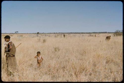 Food Gathering, Children: Woman gathering tsi, with a child standing behind her, other people gathering in the background