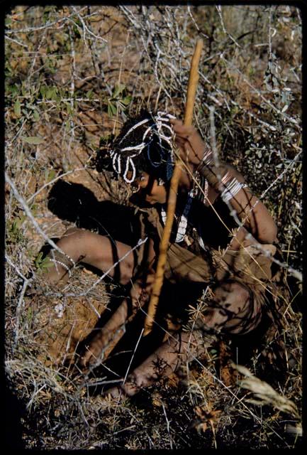 Food Gathering, General: Woman sitting and digging, with a hole partly dug