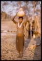 Woman carrying gourd of water on her head (out of focus)