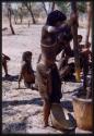 Girl pounding millet, profile