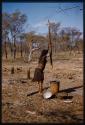 Woman pounding millet, profile
