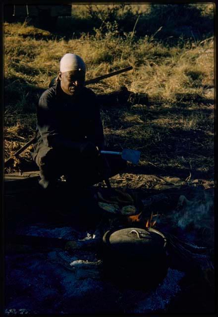 Philip Hameva sitting by a pot on the fire