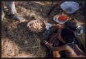 Boy lying on stomach looking at a bowl of shiva beans and nuts