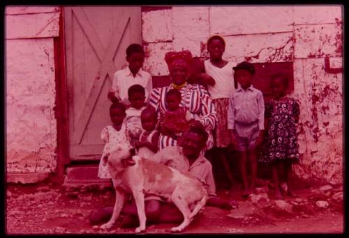 Philip Hameva and Olga (his wife) with their children and dog in front of their house