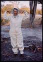 Lorna Marshall in a tsetse fly protective clothing, gesturing with her hands up