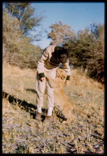 Deborah Marshall bent over to pet a lion cub hugging her