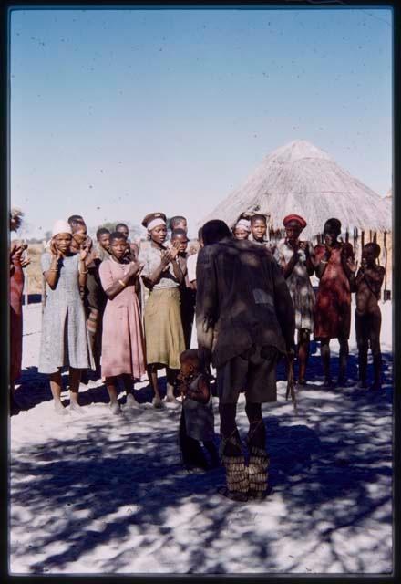 Man and baby dancing, with a group of people clapping