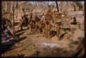 Children standing around meat hung on a trellis