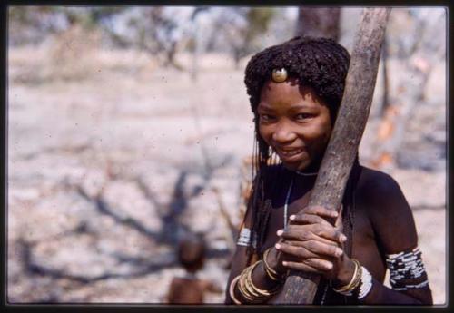 Girl holding onto a tree branch, close up view