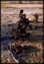 Three girls sitting by a fire