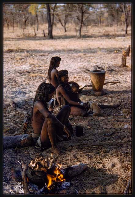 Three girls sitting by a fire