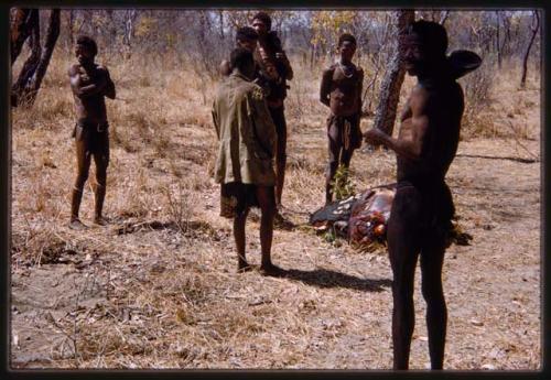 Men standing around buffalo meat being distributed