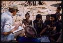 Group of women clapping; Nicholas England and Kernel Ledimo sitting with them