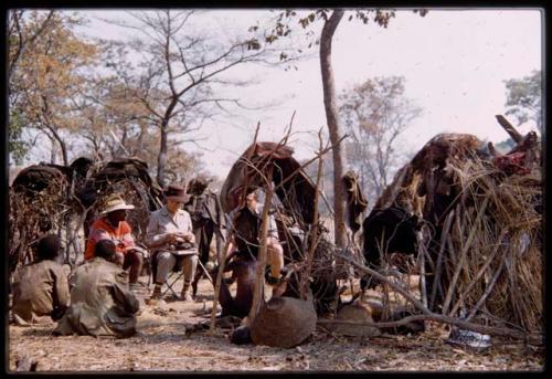 Lorna Marshall, Nicholas England, and Kernel Ledimo sitting with a group of people