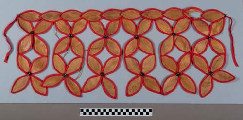 Kiekie of stylized flowers with red cloth edging and glass buttons