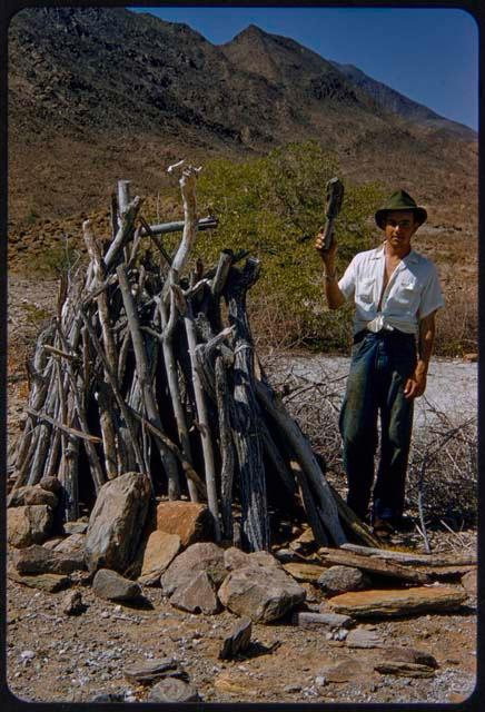 Kurt Ahrens, mechanic for the expedition, standing next to a hut