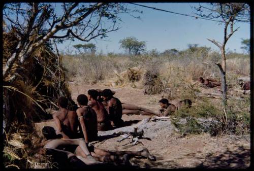 Groups: "/Gao Music" playing a //guashi and singing, sitting with a group of men in front of a skerm