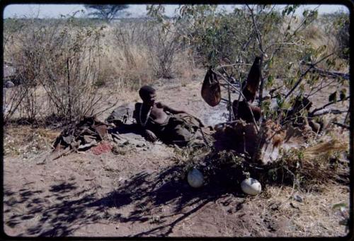 Groups: Khwo//o (mother of "/Gao Music") lying on a kaross in her dwelling place without a skerm