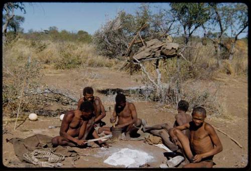 Groups: Men sitting with "Old Gau" at his dwelling place, including "Old ≠Toma," ≠Gao, "Old /Gaishay," and /Qui (Gau's son-in-law); Gau cracking nuts with a fire paddle and ≠Gao pounding something with a mortar and pestle