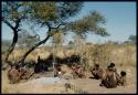 Groups, Extended Family: "Gao Helmet" shaping an assegai blade, hammering it on a stone, sitting with members of his family