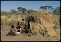 Groups, Extended Family: People sitting in front of Gau's skerm, with a kudu head on the ground next to the skerm