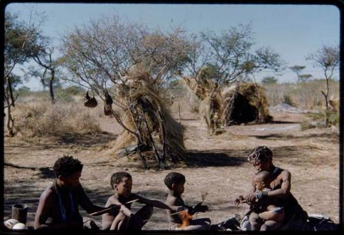 Groups, "Nuclear Family": ≠Toma working on arrows, sitting with !U and their children, close-up