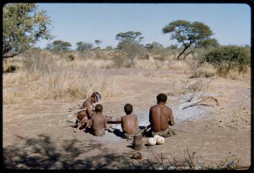 Groups, "Nuclear Family": ≠Toma working on arrows, sitting with !U and their children, view from behind